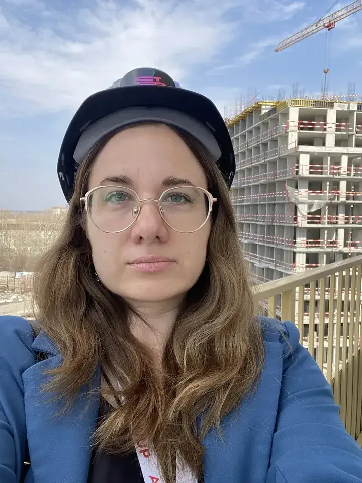 Ольга Ярославцева в каске на фоне строящегося дома в Тюмени